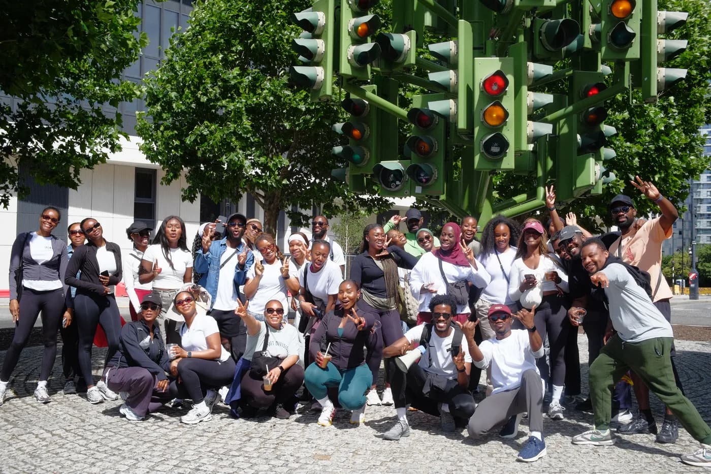 Walkers posing together beneath the Traffic Light Tree in London